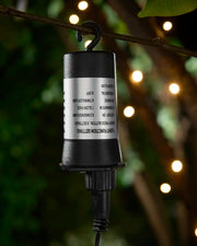 3AA Battery Box hanging from branch with warm white LEDs blurred in the background