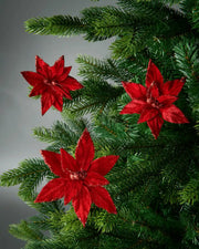 3 Red poinsettia flowers on a Christmas tree against a grey background