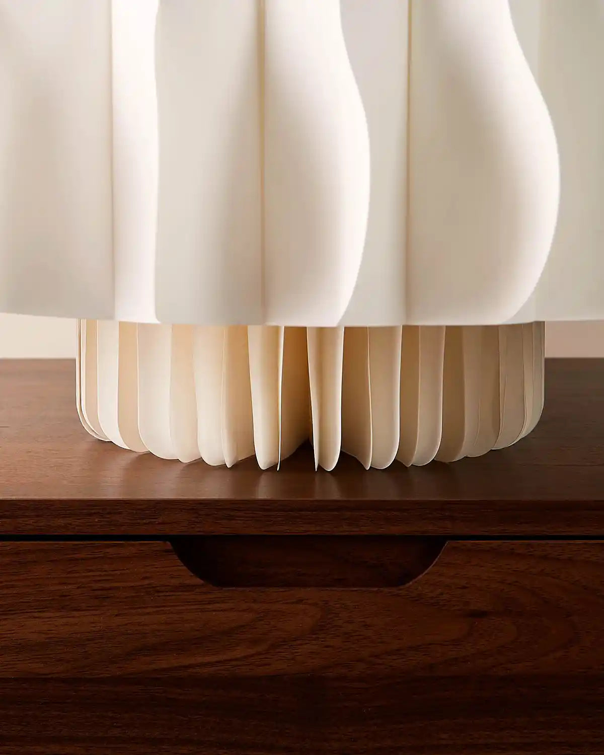 Base detail of a 3ft off-white paper honeycomb Christmas tree standing on a wooden surface.