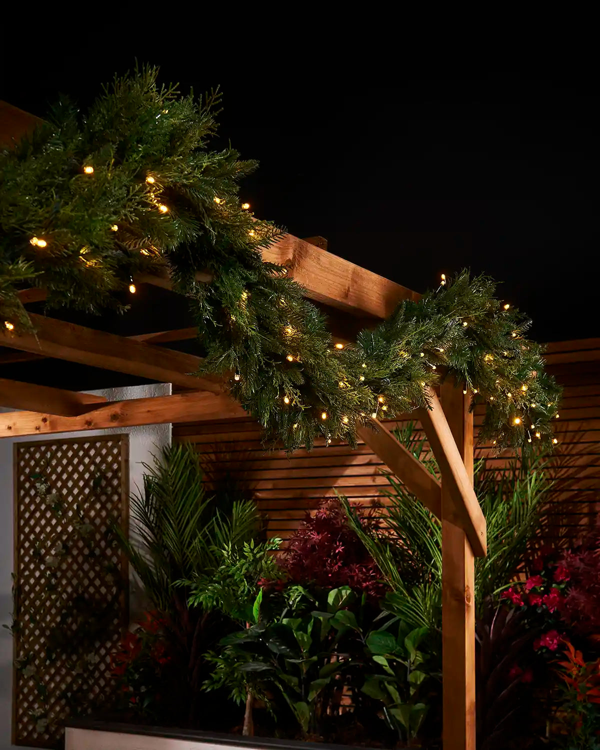 3m pre-lit natural fir garland with warm white LEDs displayed along a wooden pergola.