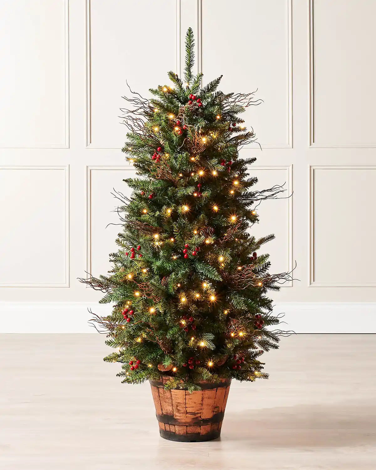 Pre-lit 4.5 ft pines and berries potted Christmas tree in a wooden barrel-style pot with warm white lights