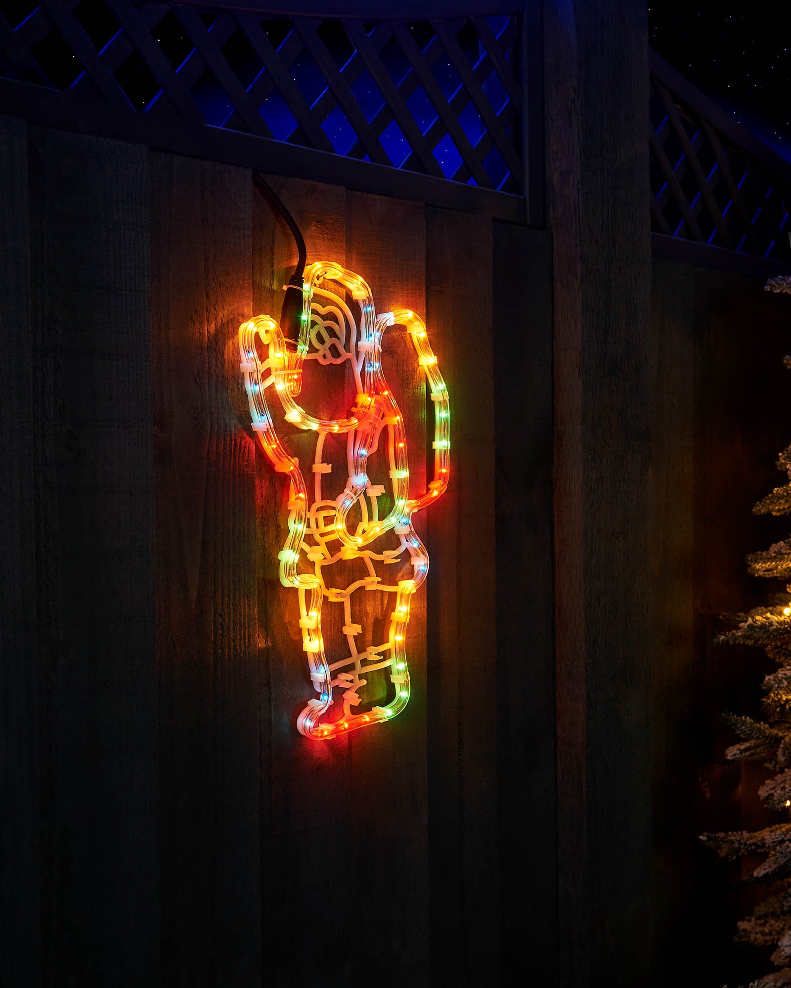 Angled view of the multi-coloured Santa with sack rope light on a fence