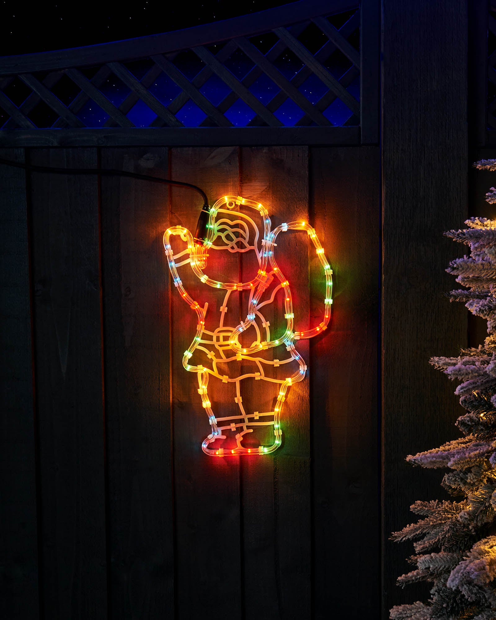 41 cm Santa and sack rope light displayed outdoors beside a frosted Christmas tree