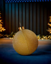 Gold 45cm inflatable tinsel Christmas bauble with a gold cap in an outdoor festive display.