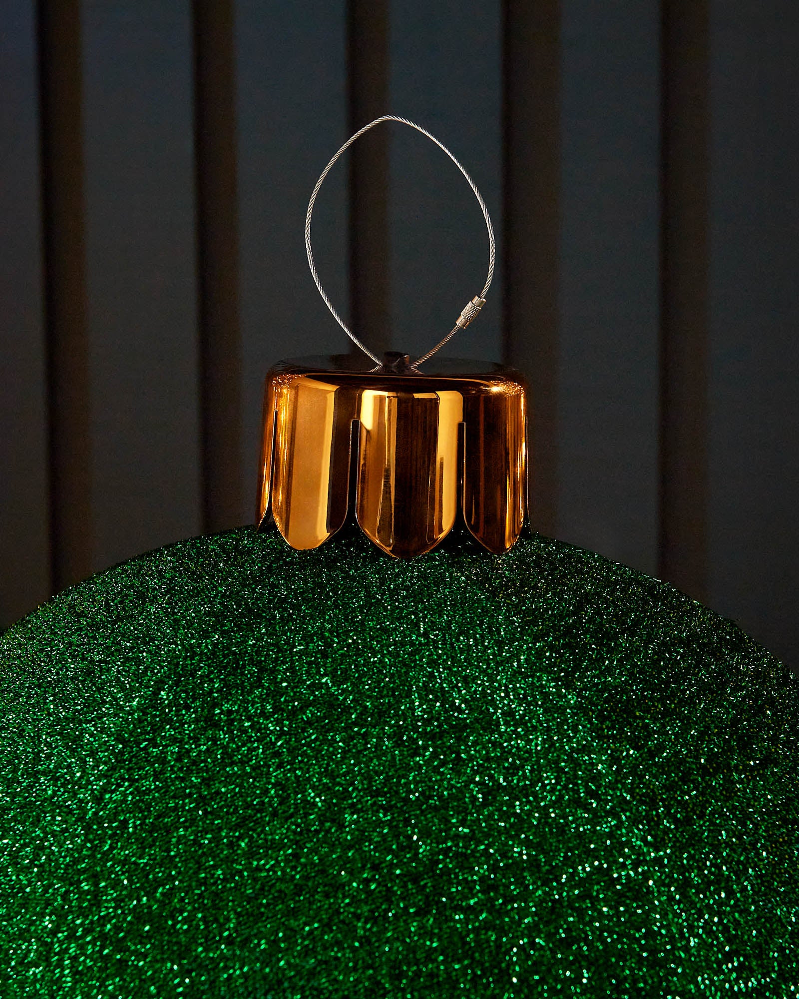 Close-up of the gold cap and hanging wire on a green 45cm inflatable tinsel Christmas bauble.