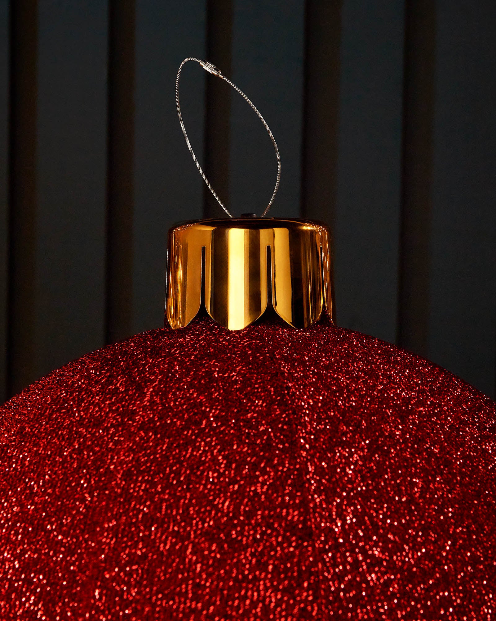 Close-up of the gold cap and hanging wire on a red 45cm inflatable tinsel Christmas bauble.