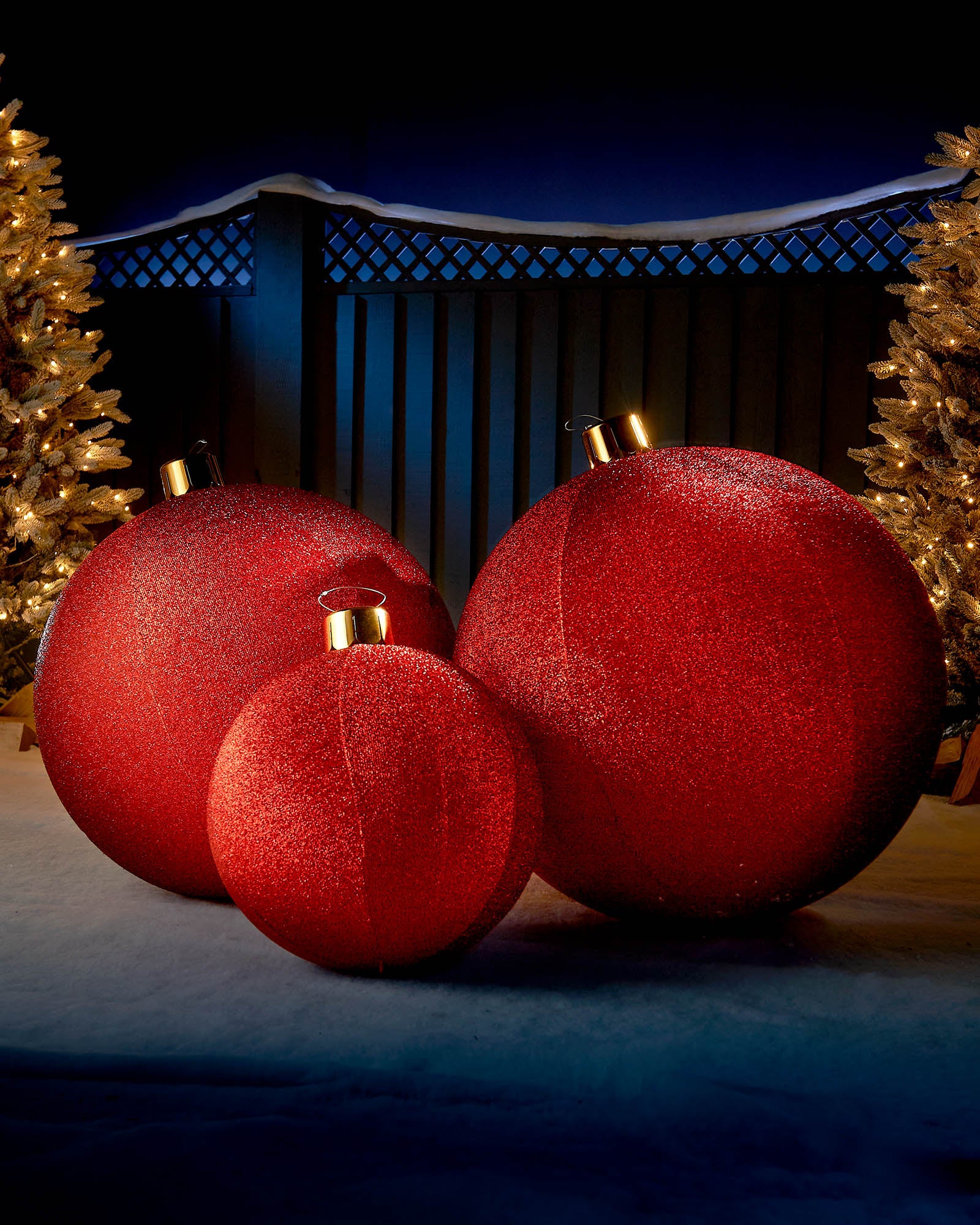 Red 45cm inflatable tinsel Christmas baubles displayed outdoors with warm festive lights.