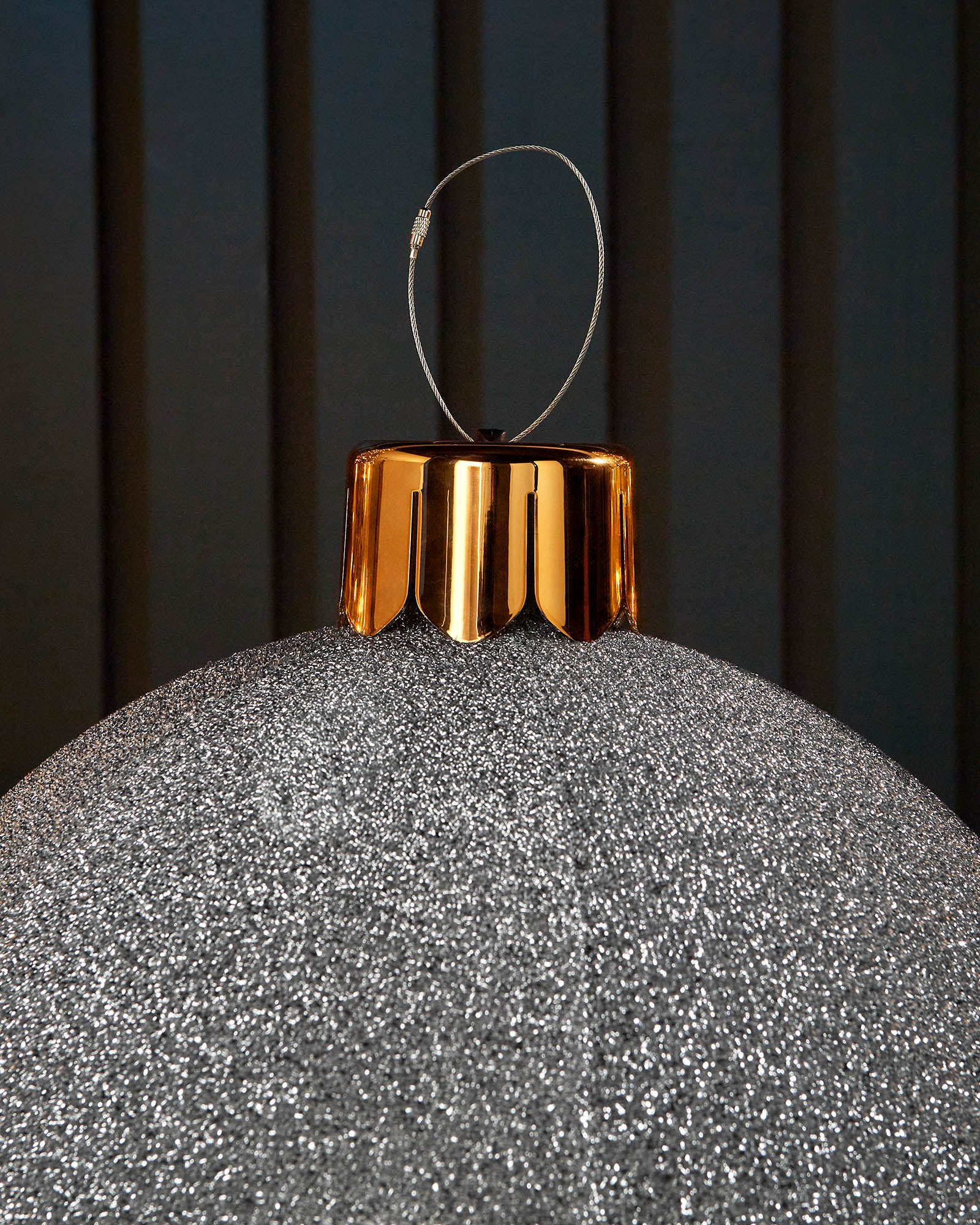 Close-up of the gold cap and hanging wire on a silver 45cm inflatable tinsel Christmas bauble.