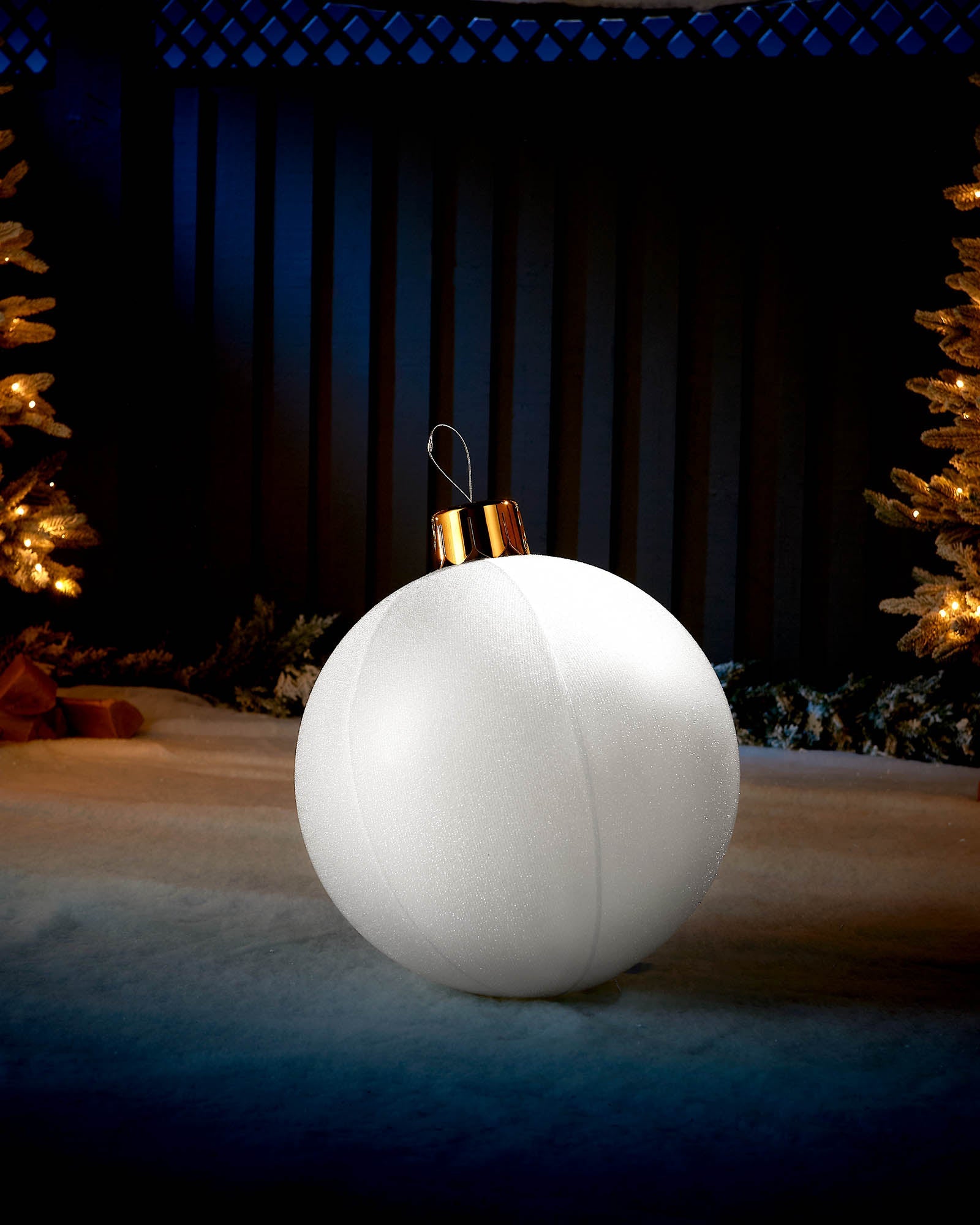 White 45cm inflatable tinsel Christmas bauble with a gold cap in an outdoor festive display.