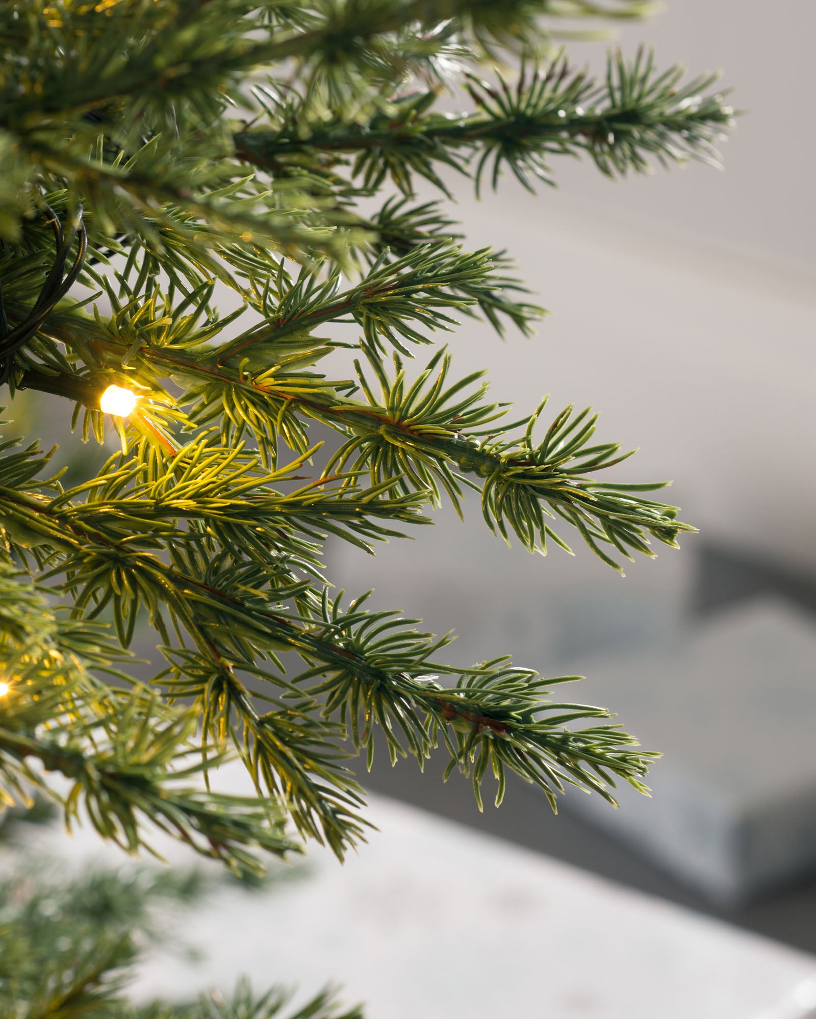 Pre-lit Traditional Fir Christmas tree with dense, mixed PE and PVC foliage, illuminated by warm white LED lights. Featuring multi-functional lighting settings and a low voltage transformer for safe indoor and outdoor use. Displayed with a lush, lifelike appearance and a classic silhouette.
