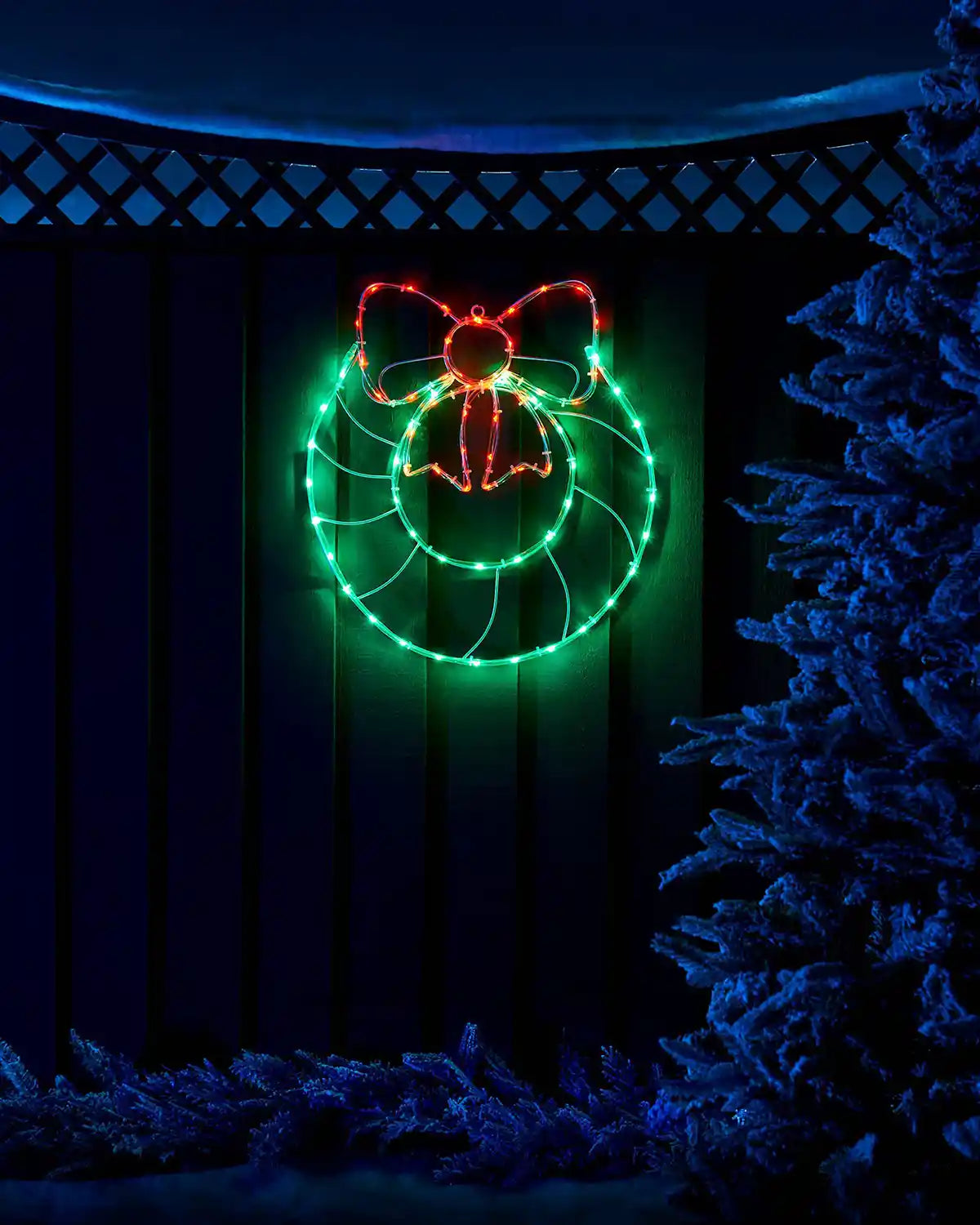 50 cm pre-lit wreath and bow rope light glowing in an outdoor Christmas scene