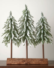 Snow-flocked tree trio with green fir branches and a natural-look log base, 50cm tall.