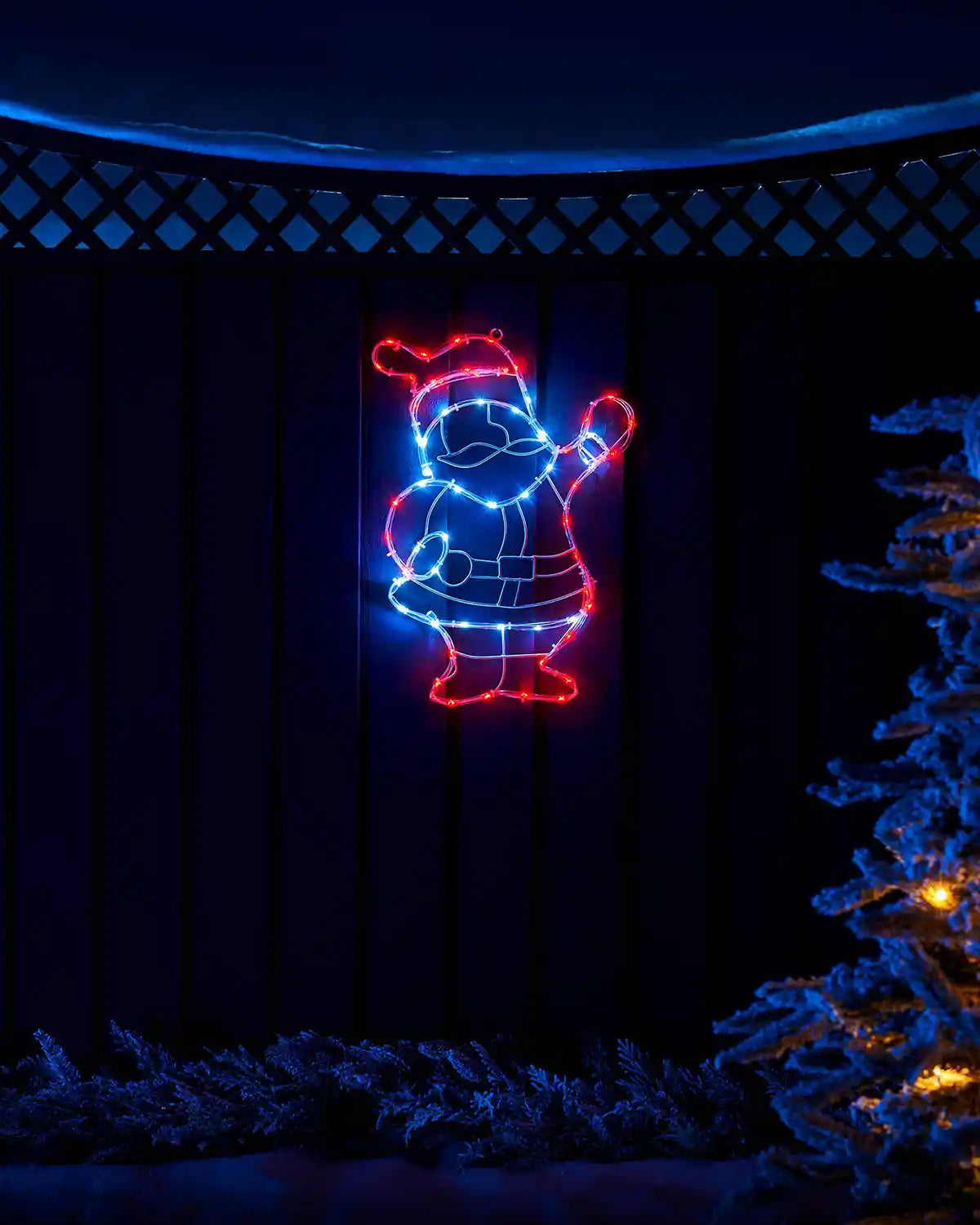51 cm pre-lit waving Santa silhouette glowing in an outdoor Christmas display