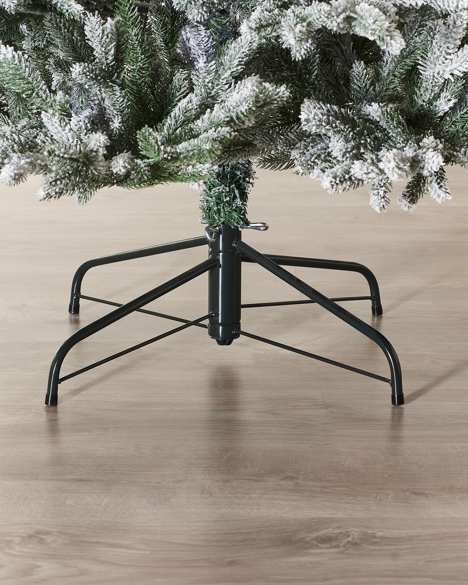 Luxury snow-flocked artificial Christmas tree with soft, snow-dusted tips and a full-bodied, naturalistic shape. Features hinged branches for easy assembly and storage, providing a reusable, elegant centerpiece that captures the charm of a rustic winter wonderland.