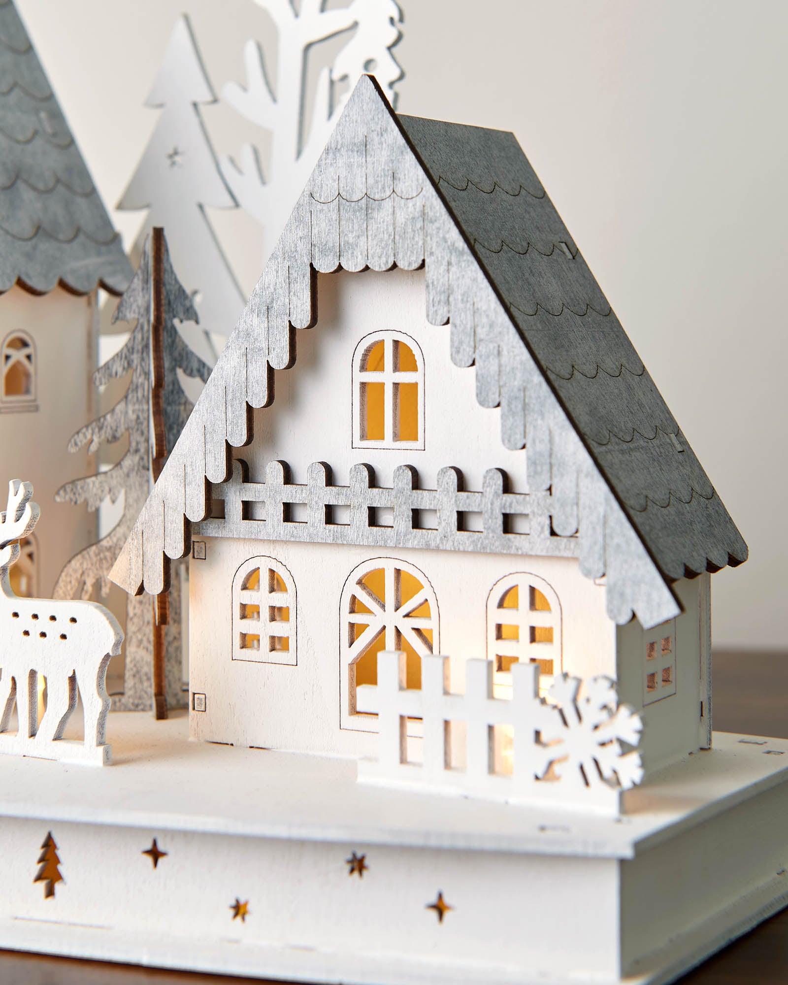 Set of decorative houses with lights on a neutral background