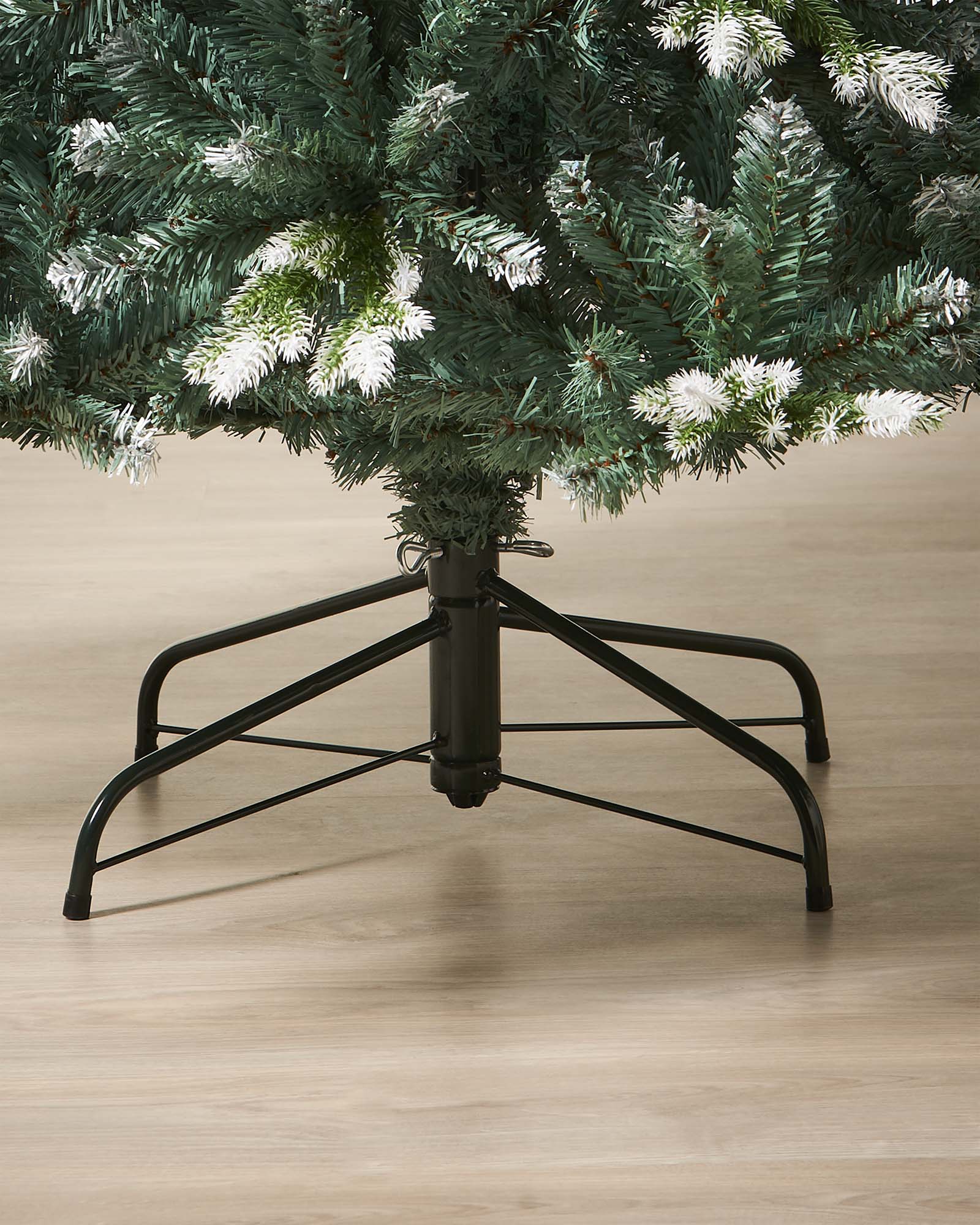 Life-like Evergreen Christmas tree with white snow-flocked tips and mixed cool green and blue tones, featuring hinged branches for easy assembly and storage—perfect for creating a trendy, rustic festive display indoors.