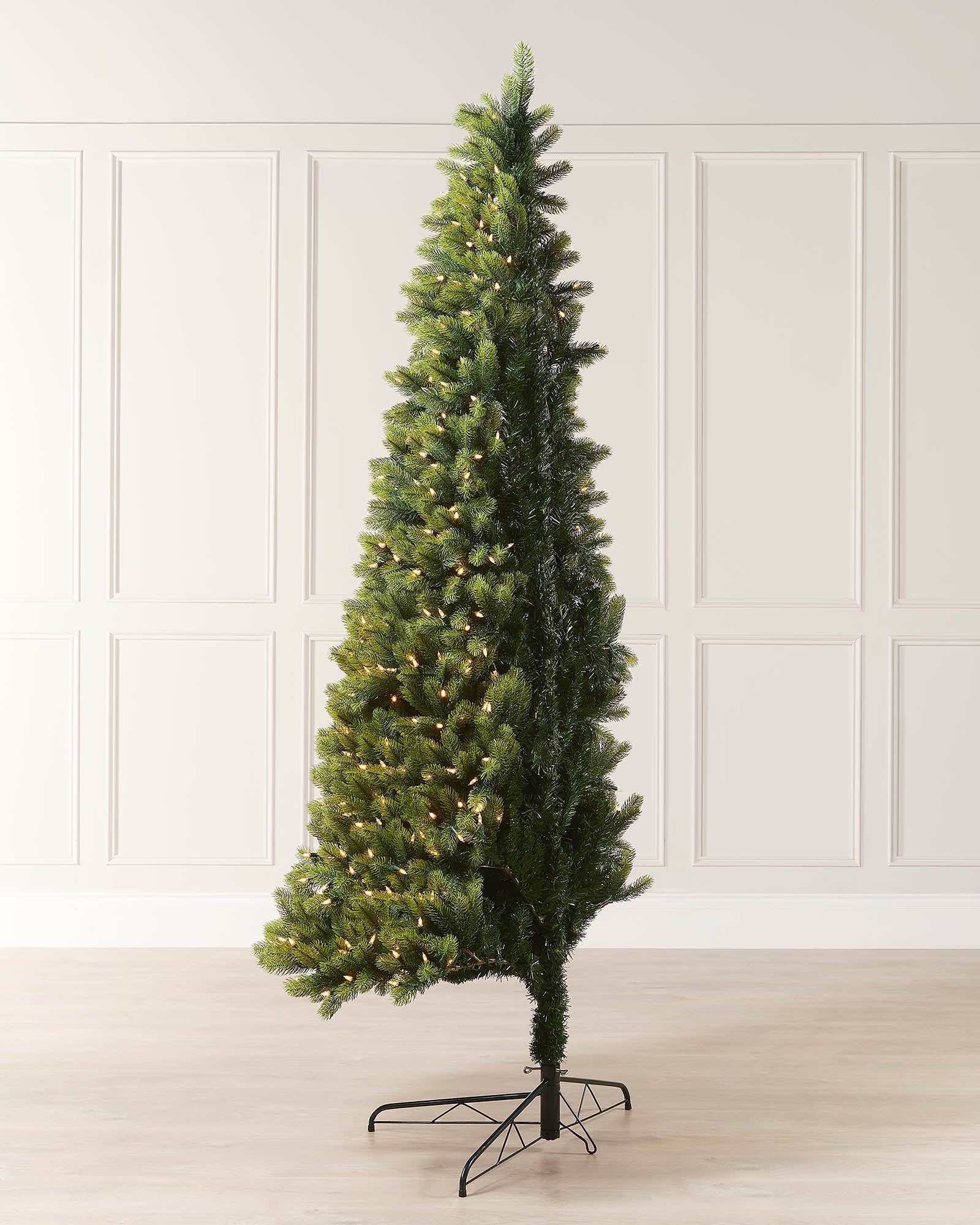 Side view of the 5ft pre-lit mixed pine half Christmas tree showing its slim wall-facing profile and warm white lights.