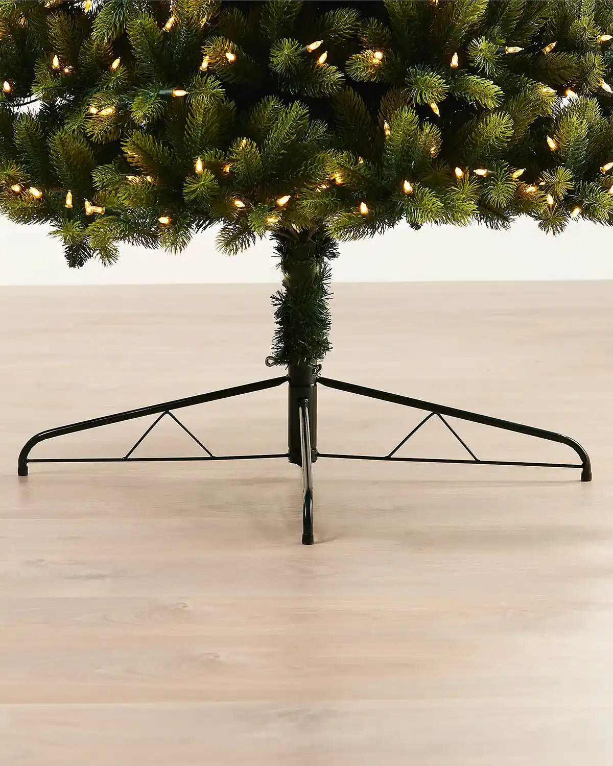Close-up of the metal tree stand supporting the 5ft pre-lit mixed pine half Christmas tree indoors.