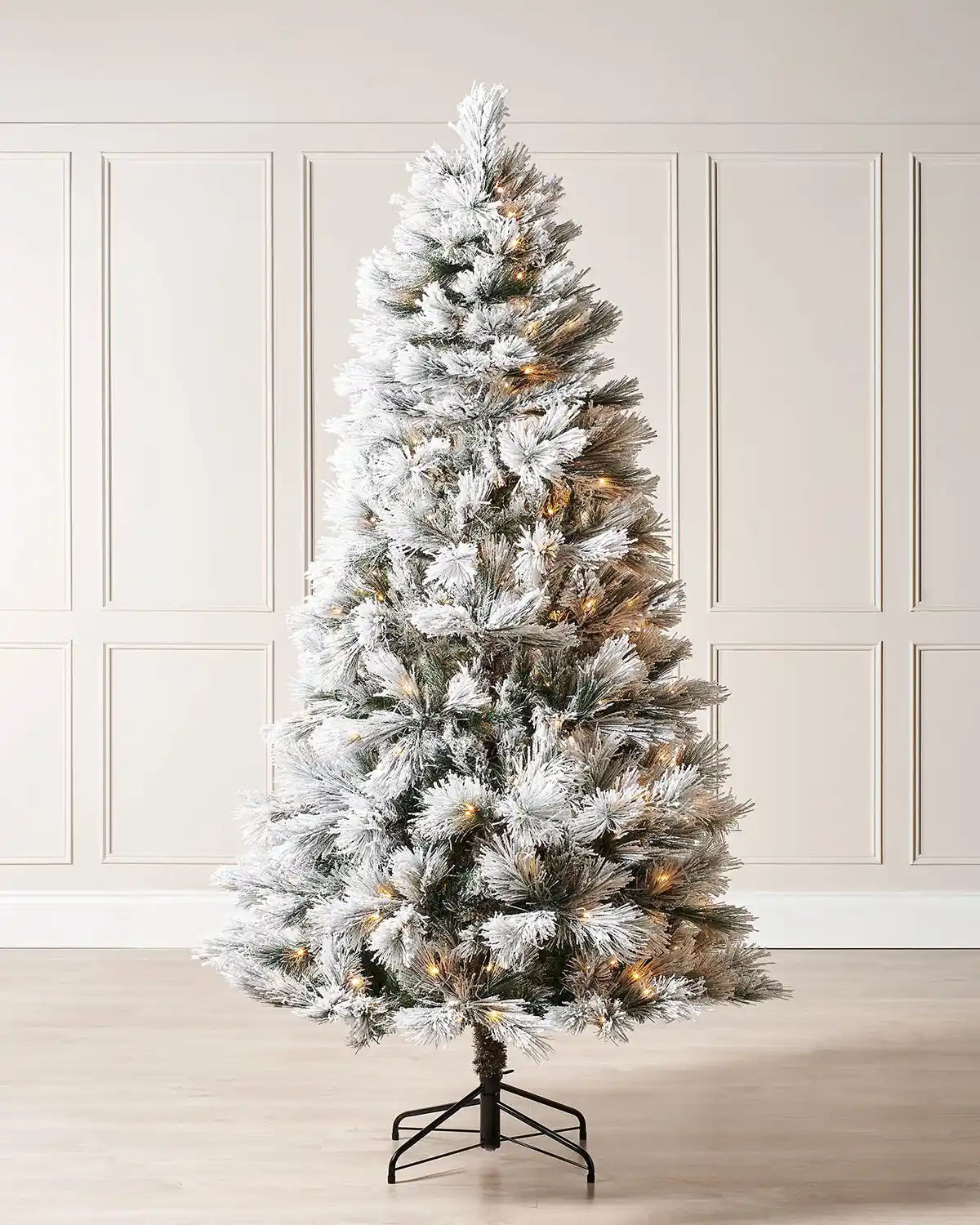 Pre-lit 5 ft snow flocked pine needle Christmas tree displayed indoors