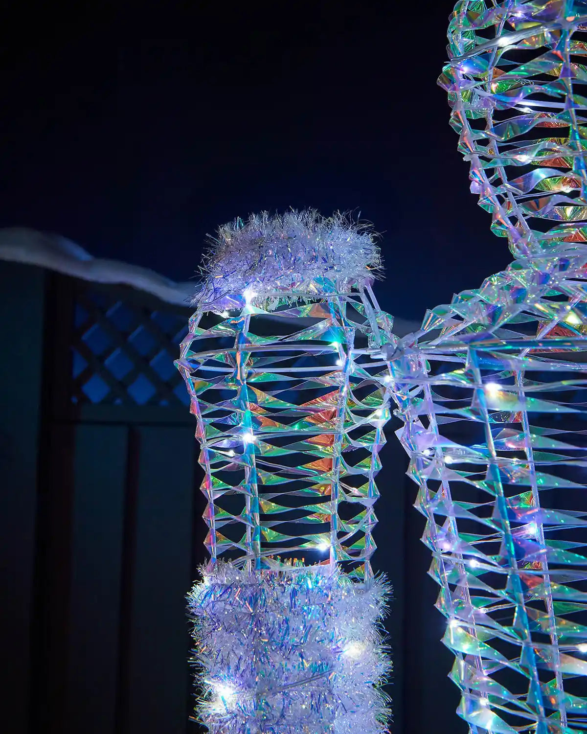 Detail of the iridescent Nutcracker arm with tinsel cuff, white LEDs and reflective frame.
