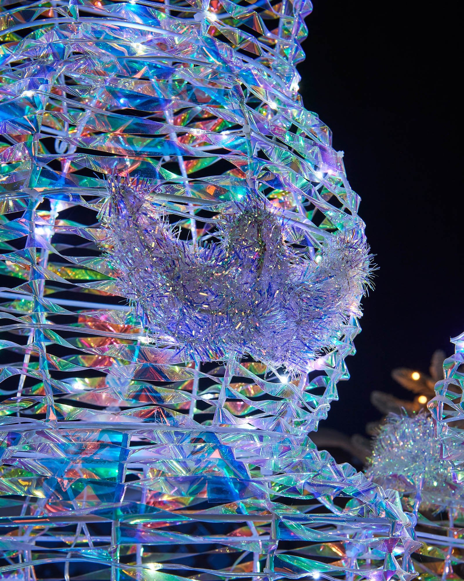 Close-up of the iridescent Nutcracker face with sculpted moustache, tinsel trim and white LEDs.