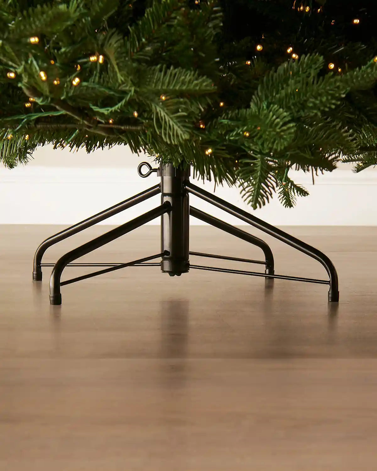 Close-up of the metal tree stand beneath a pre-lit Noble Fir Christmas tree.