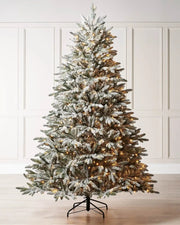 Pre-lit 6.5 ft snow flocked Christmas tree displayed indoors with warm white LEDs and a full frosted silhouette