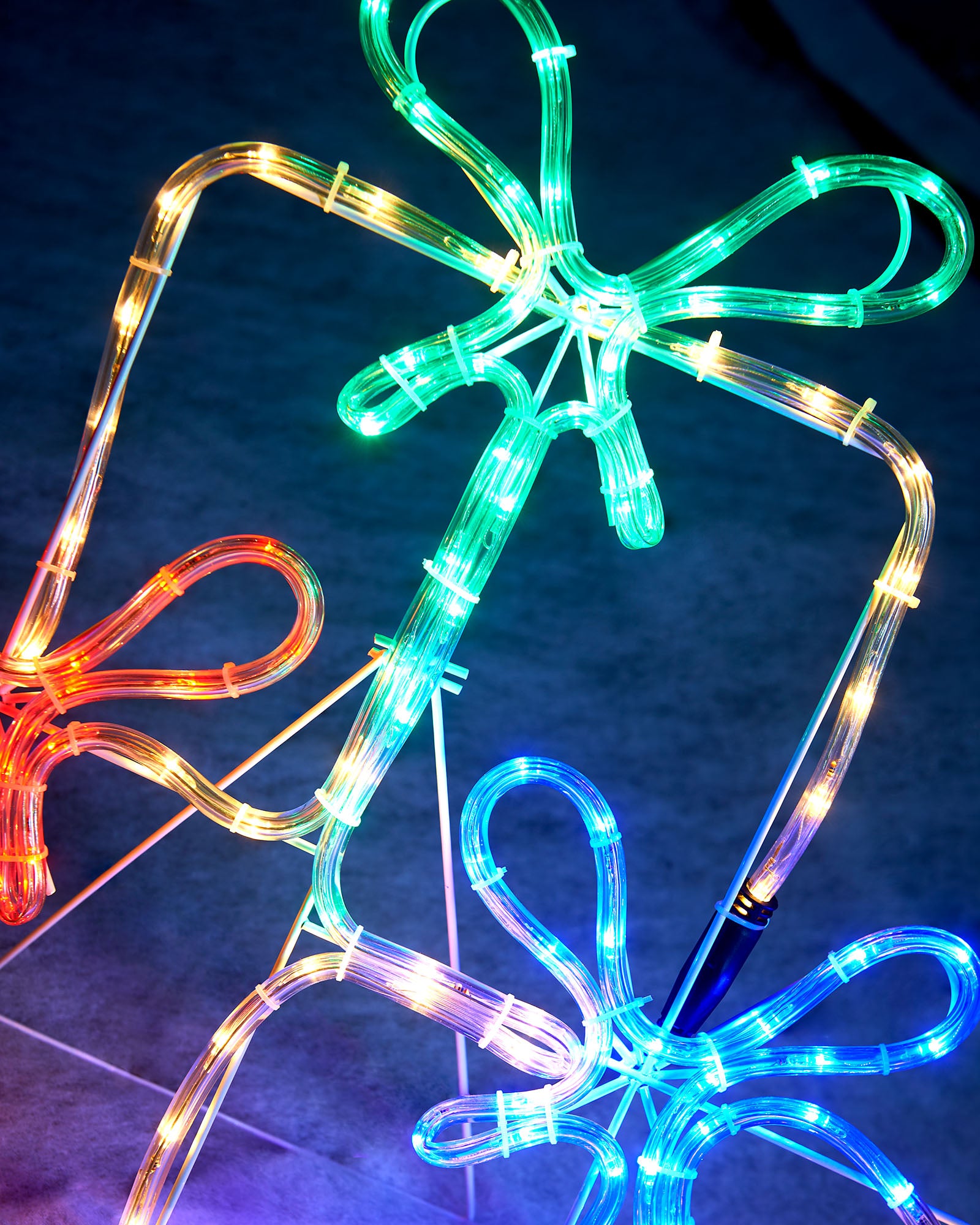 Close-up of the multi-coloured rope light bows and warm white gift box outlines