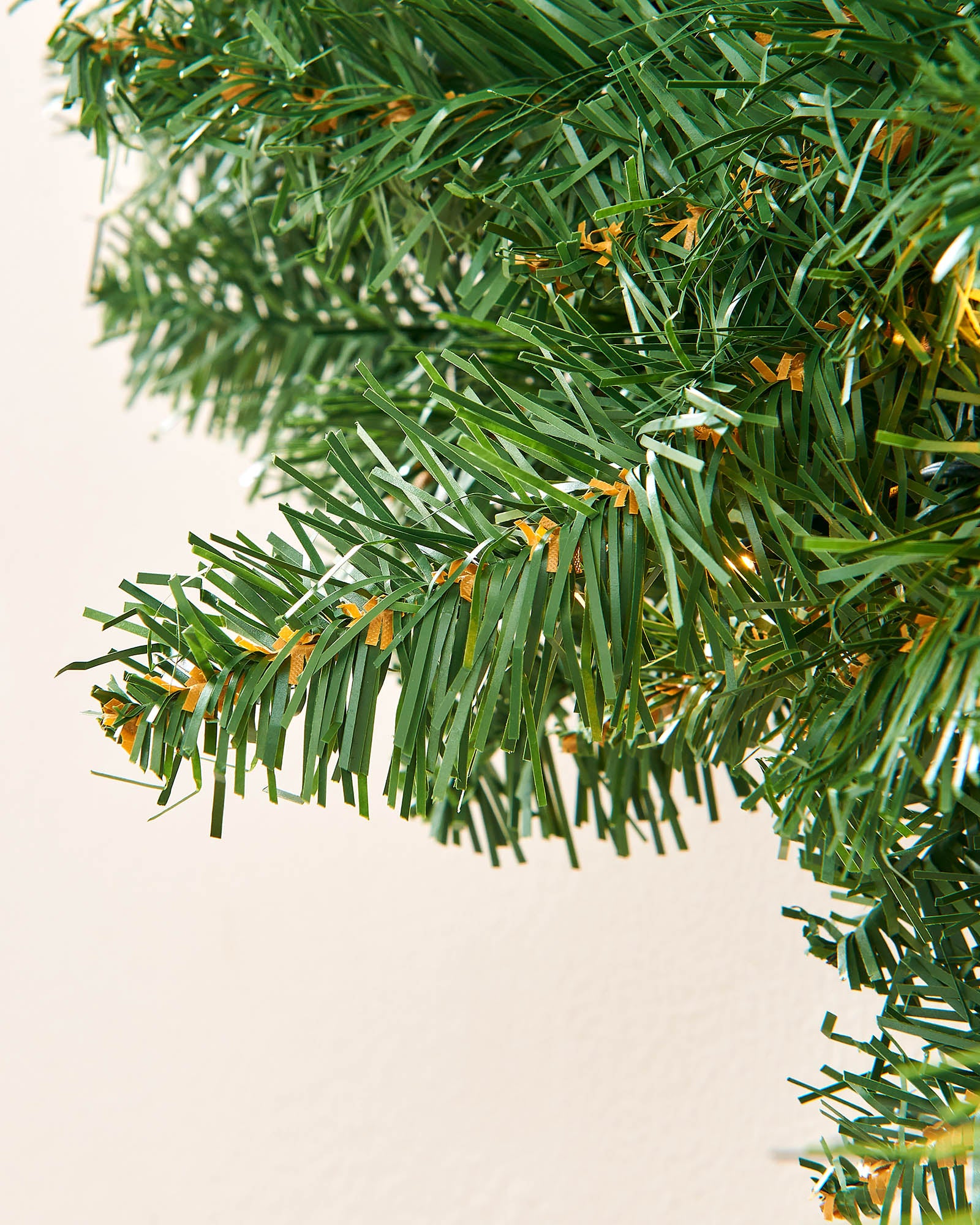 Detailed view of green artificial branches on a pre-lit Christmas wreath