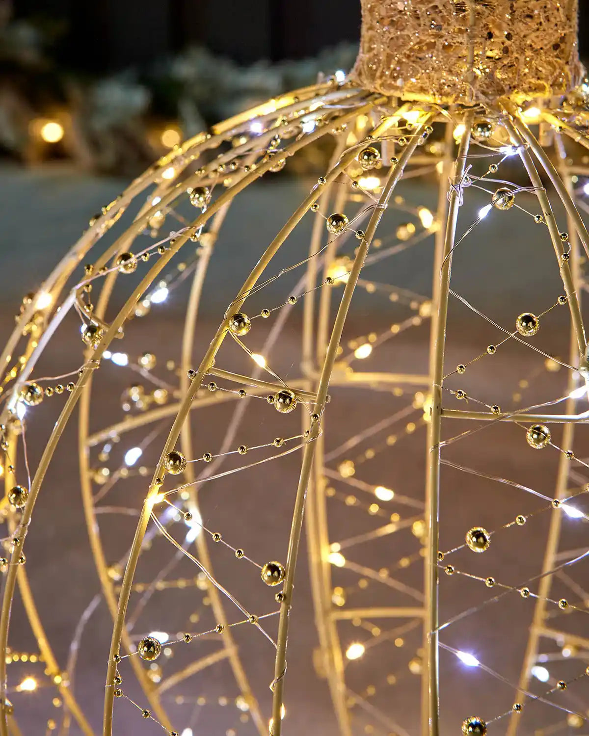 Detail close-up of the gold bauble silhouette showing beaded wire decoration and warm and bright white LEDs.