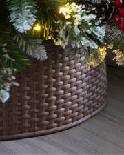 Brown 65 cm rattan effect tree collar displayed under a Christmas tree