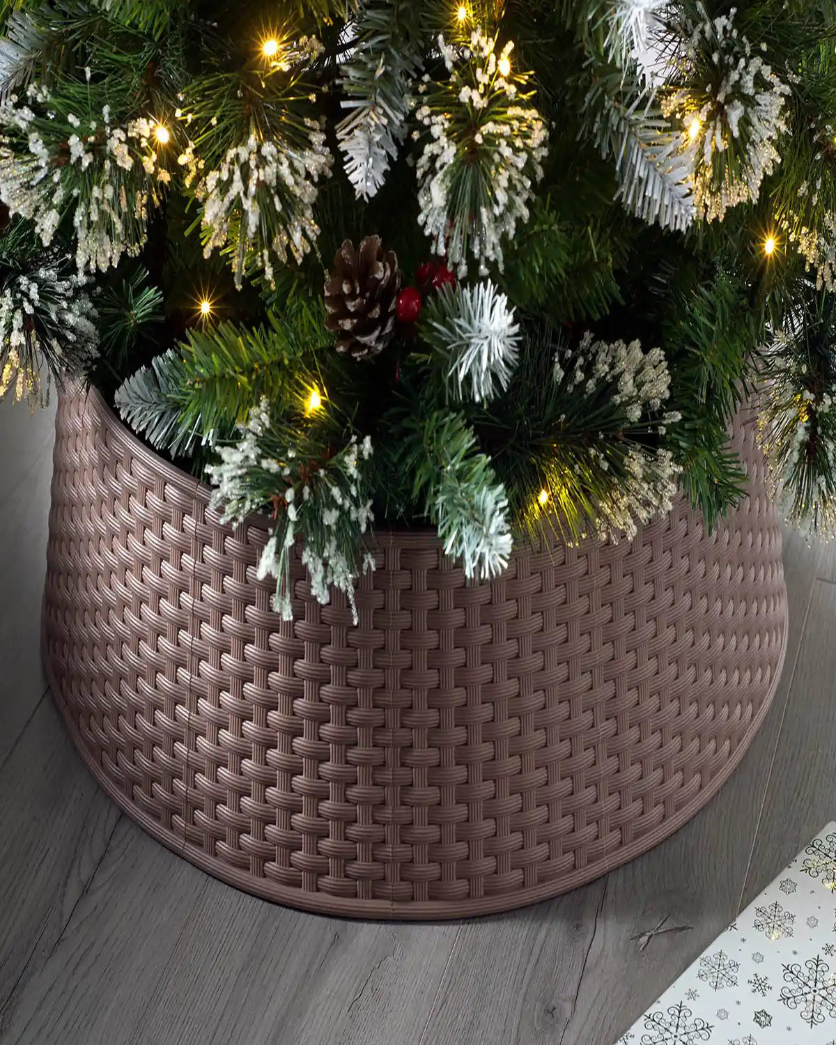 65 cm rattan effect tree collar hiding the base of a decorated Christmas tree