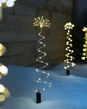 Illuminated spiral firework pathway light displayed outdoors in snow