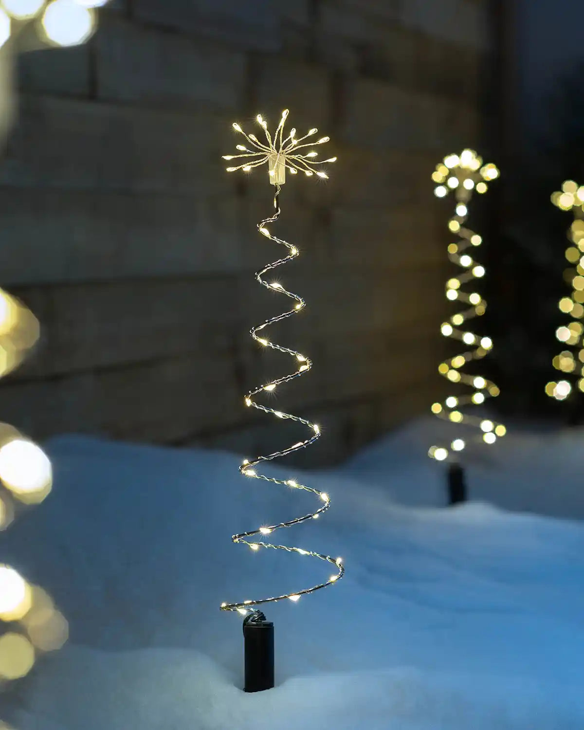 Illuminated spiral firework pathway light displayed outdoors in snow