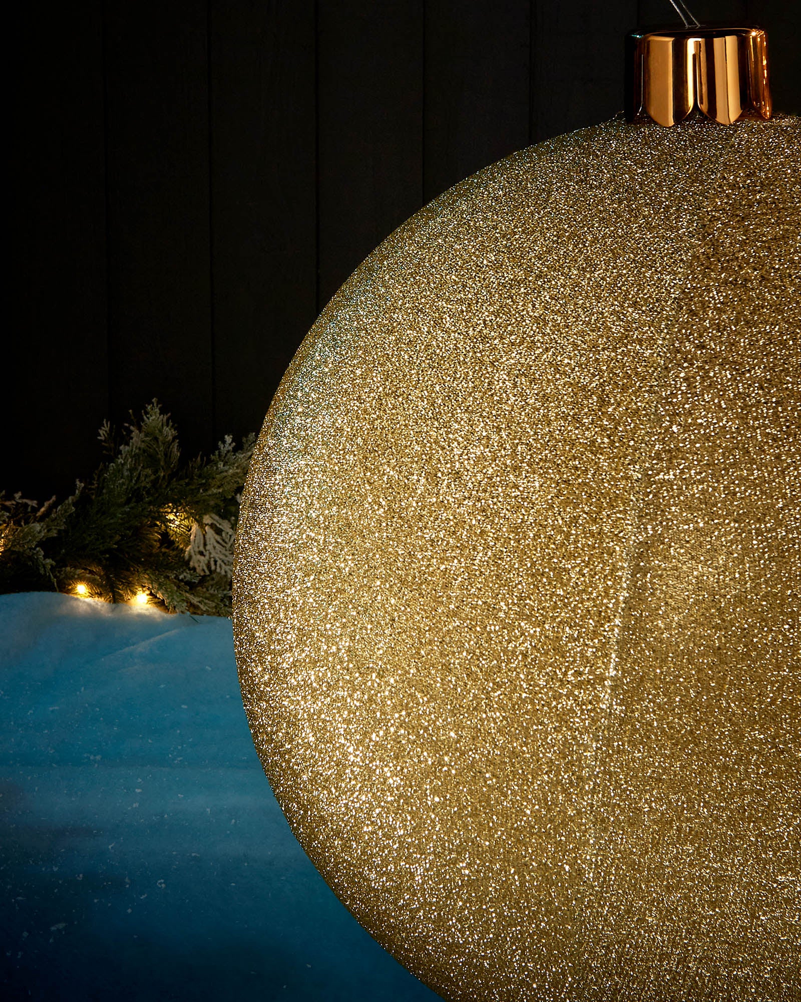 Detail close-up of the textured gold tinsel surface on a 66cm inflatable Christmas bauble.