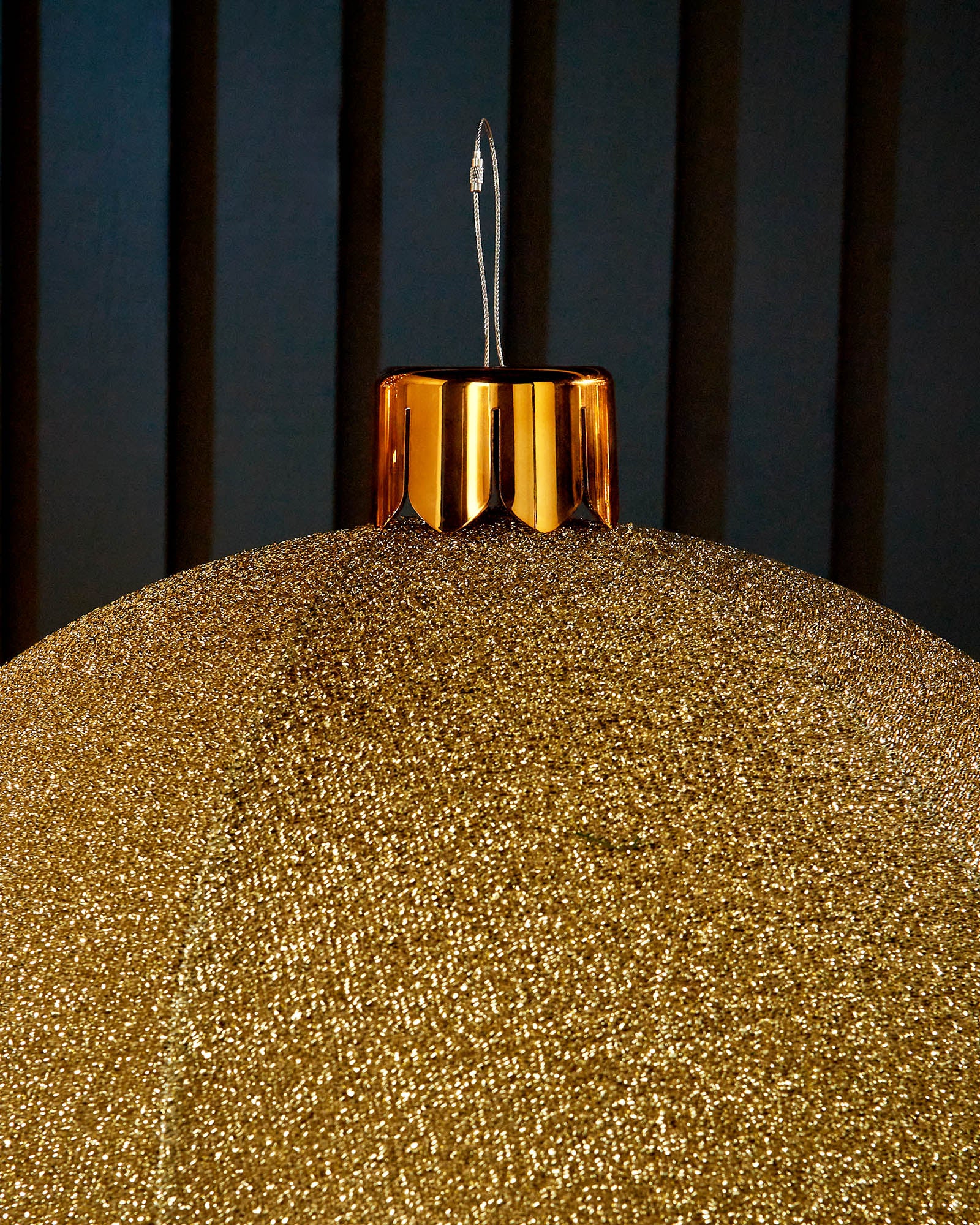 Close-up of the gold cap and hanging wire on a gold 66cm inflatable tinsel Christmas bauble.