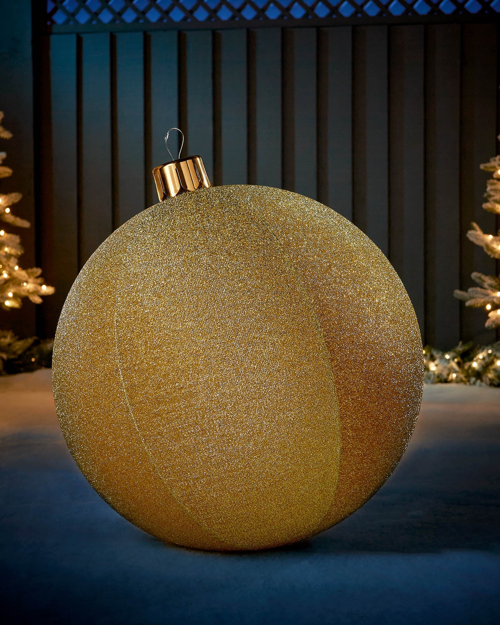 Large gold 66cm inflatable tinsel Christmas bauble with a gold cap in an outdoor festive display.