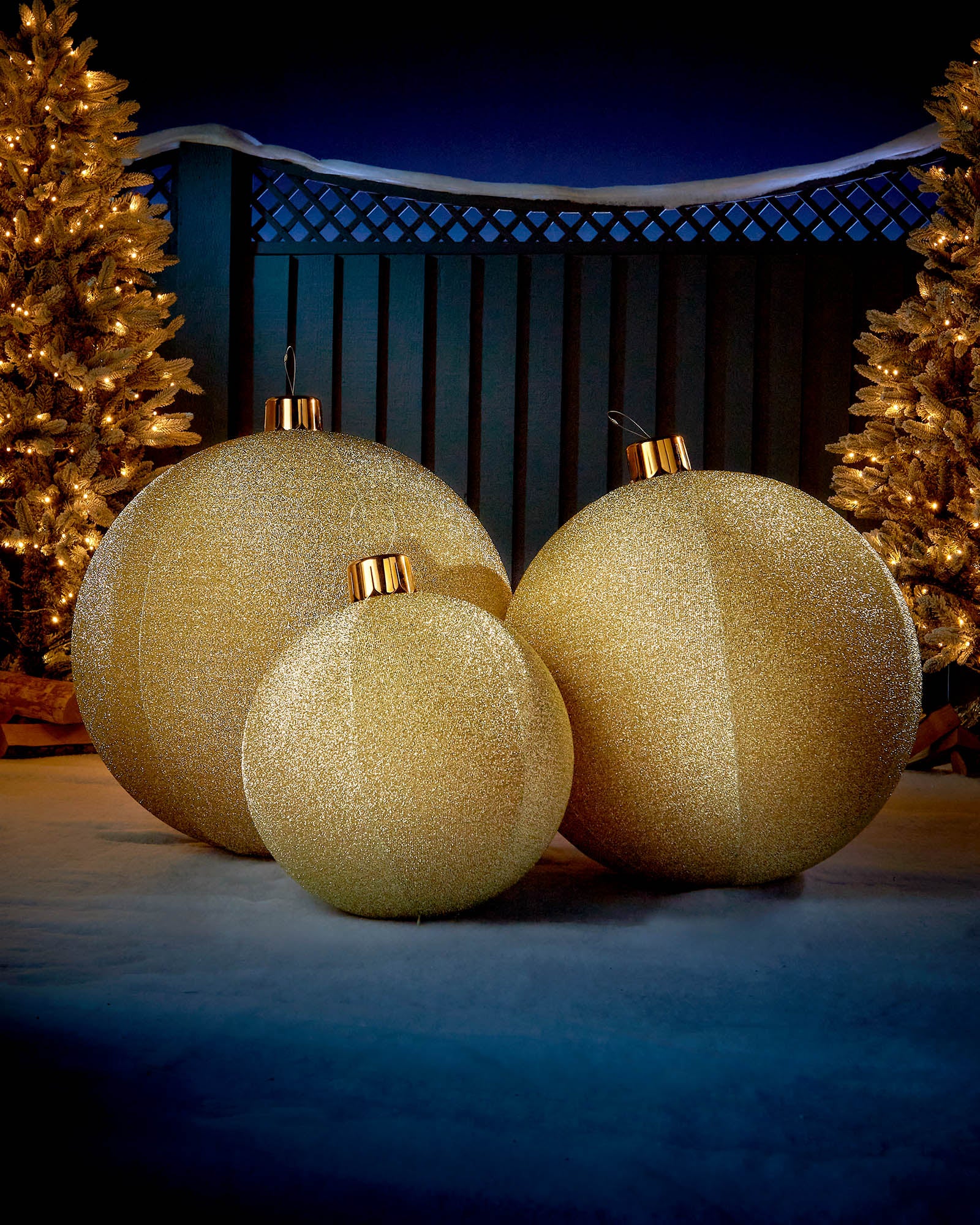 Gold 66cm inflatable tinsel Christmas baubles displayed outdoors with warm festive lights.