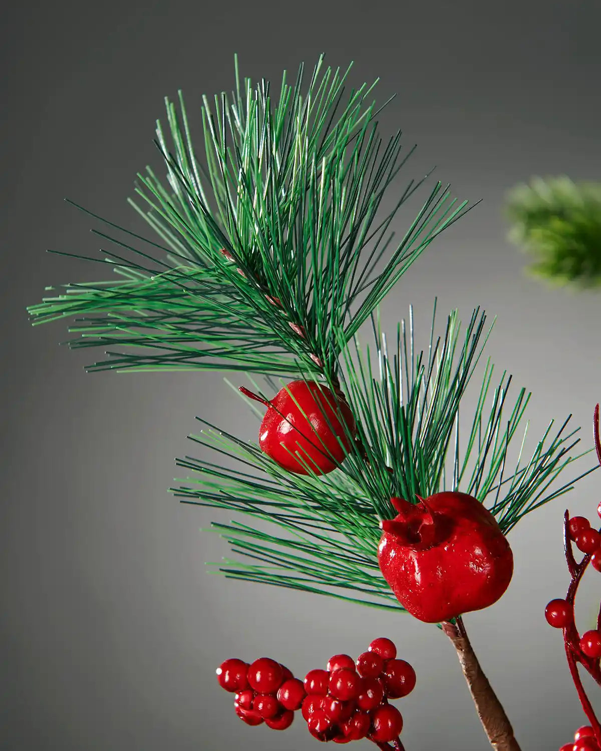 Close-up of pine sprigs and red fruit detail on the 66 cm tree pick