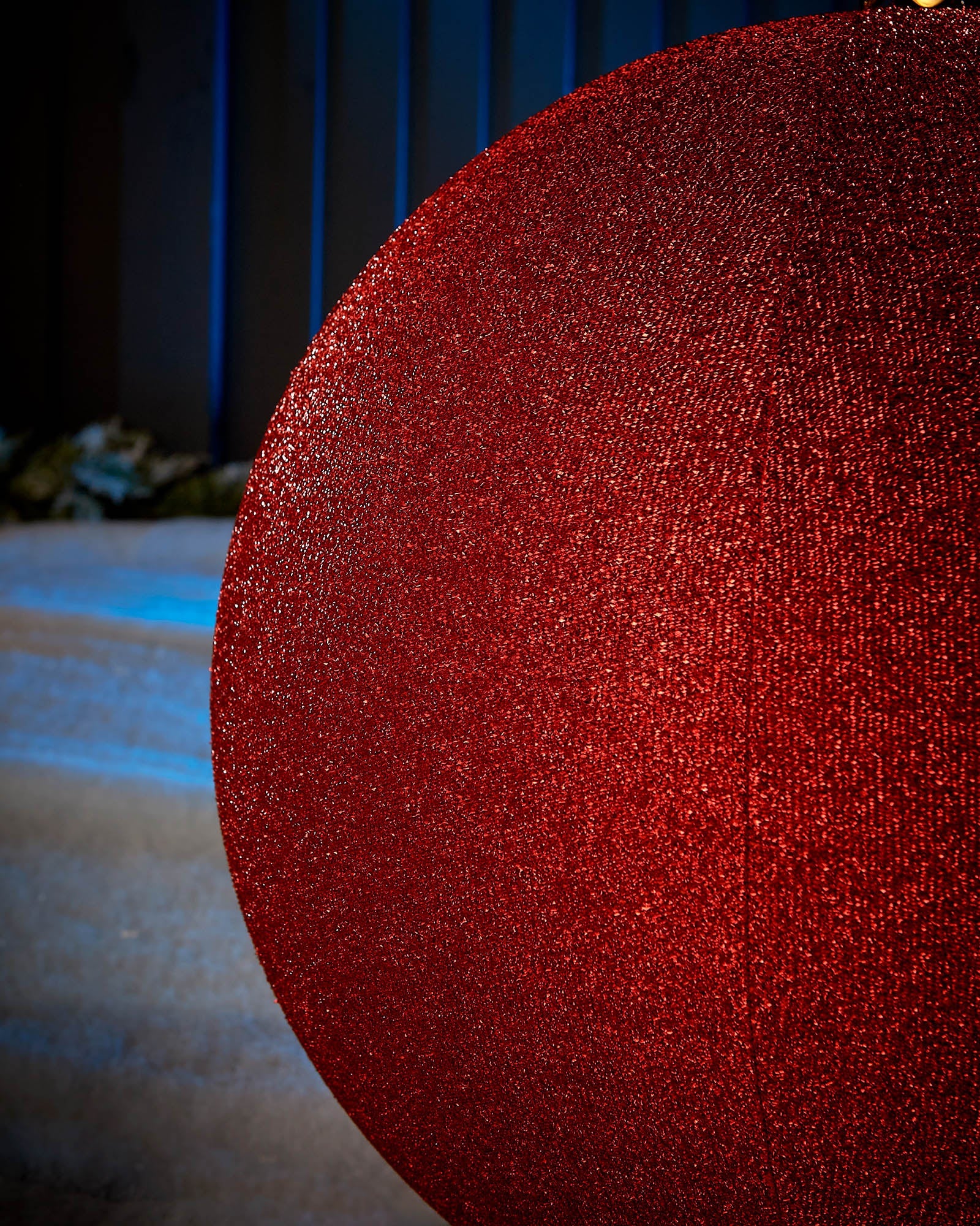 Detail close-up of the textured red tinsel surface on a 66cm inflatable Christmas bauble.