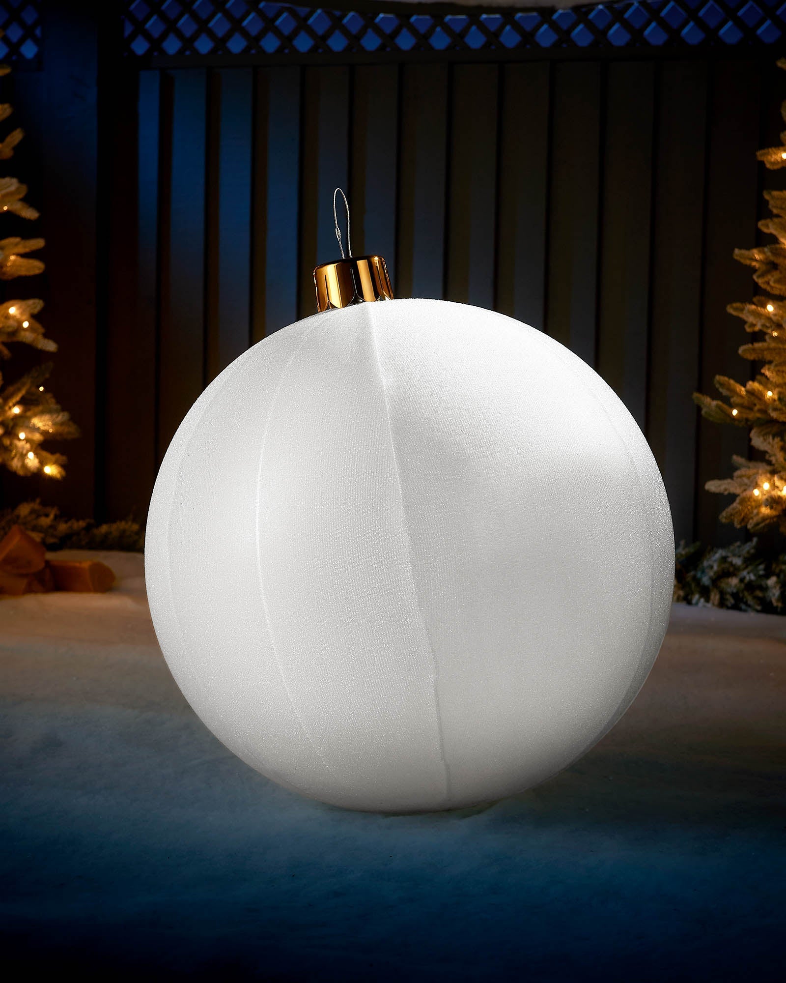Large white 66cm inflatable tinsel Christmas bauble with a gold cap in an outdoor festive display.