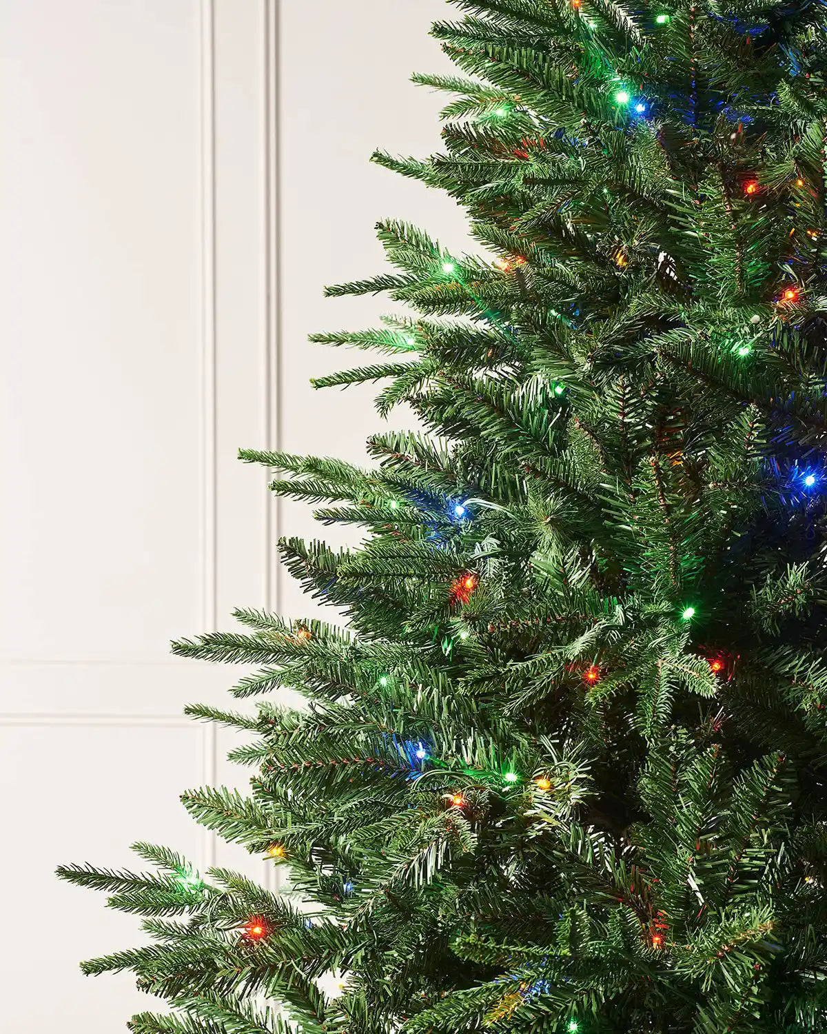 Close-up of 6ft Grand Alaskan Fir Christmas tree branches with realistic green fir tips and multicolour LEDs