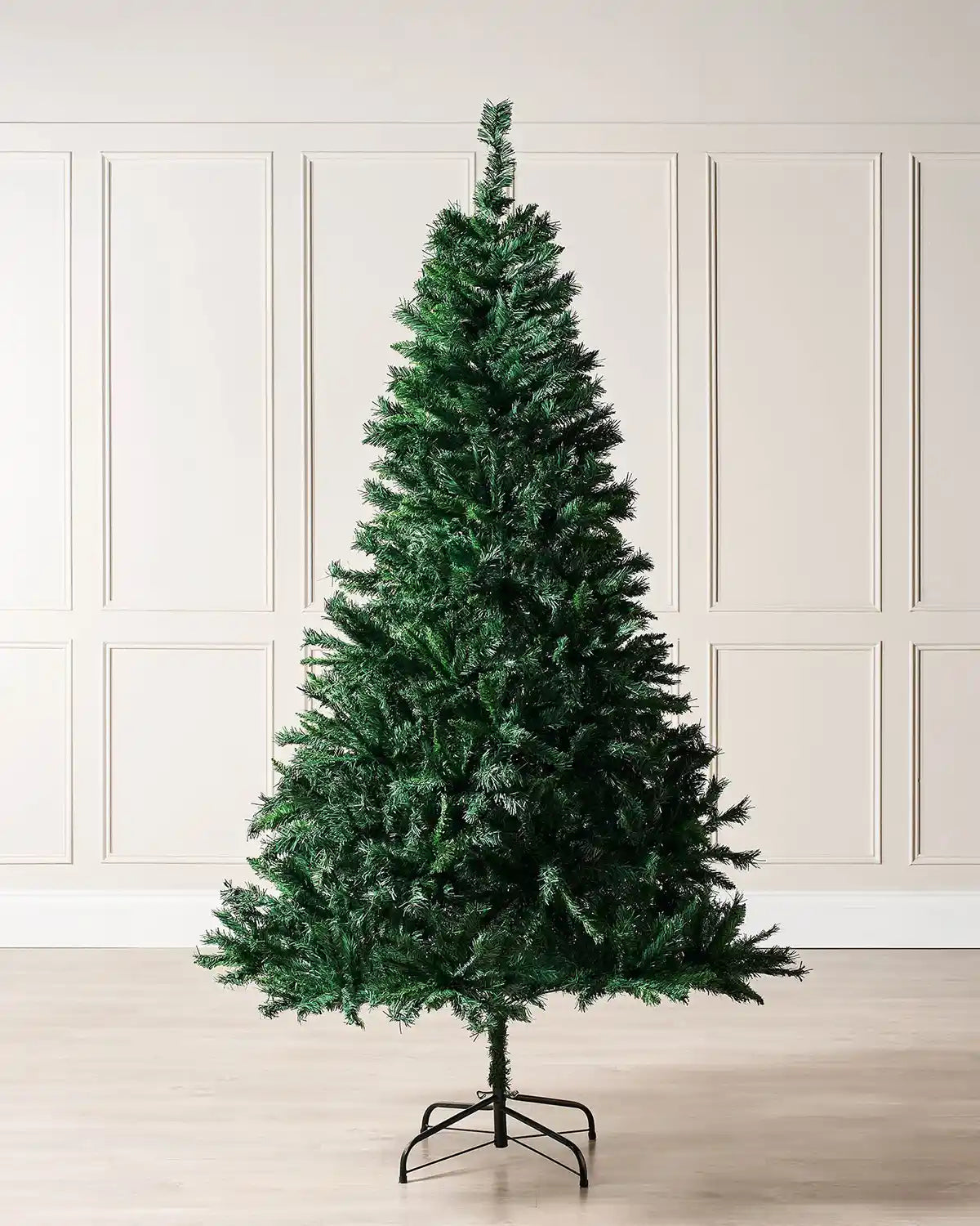 6 ft mixed pine artificial Christmas tree displayed in a room with panelled wall and dark Green metal stand