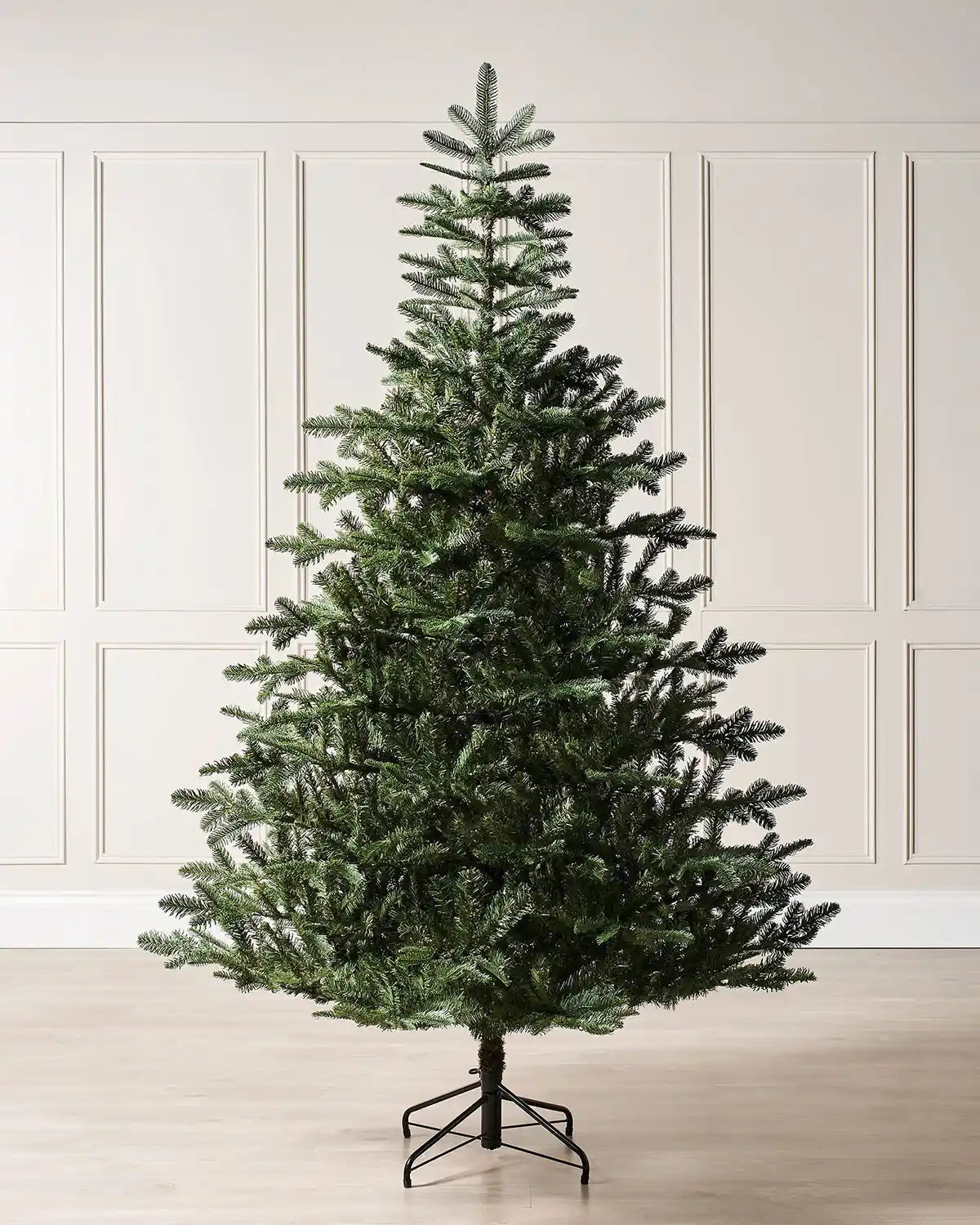 6ft green Nordmann fir Christmas tree displayed indoors against cream wall panelling