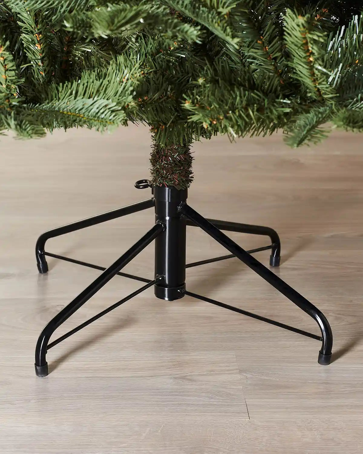 Close-up of the lower trunk and metal tree stand on a 6ft Nordmann fir Christmas tree