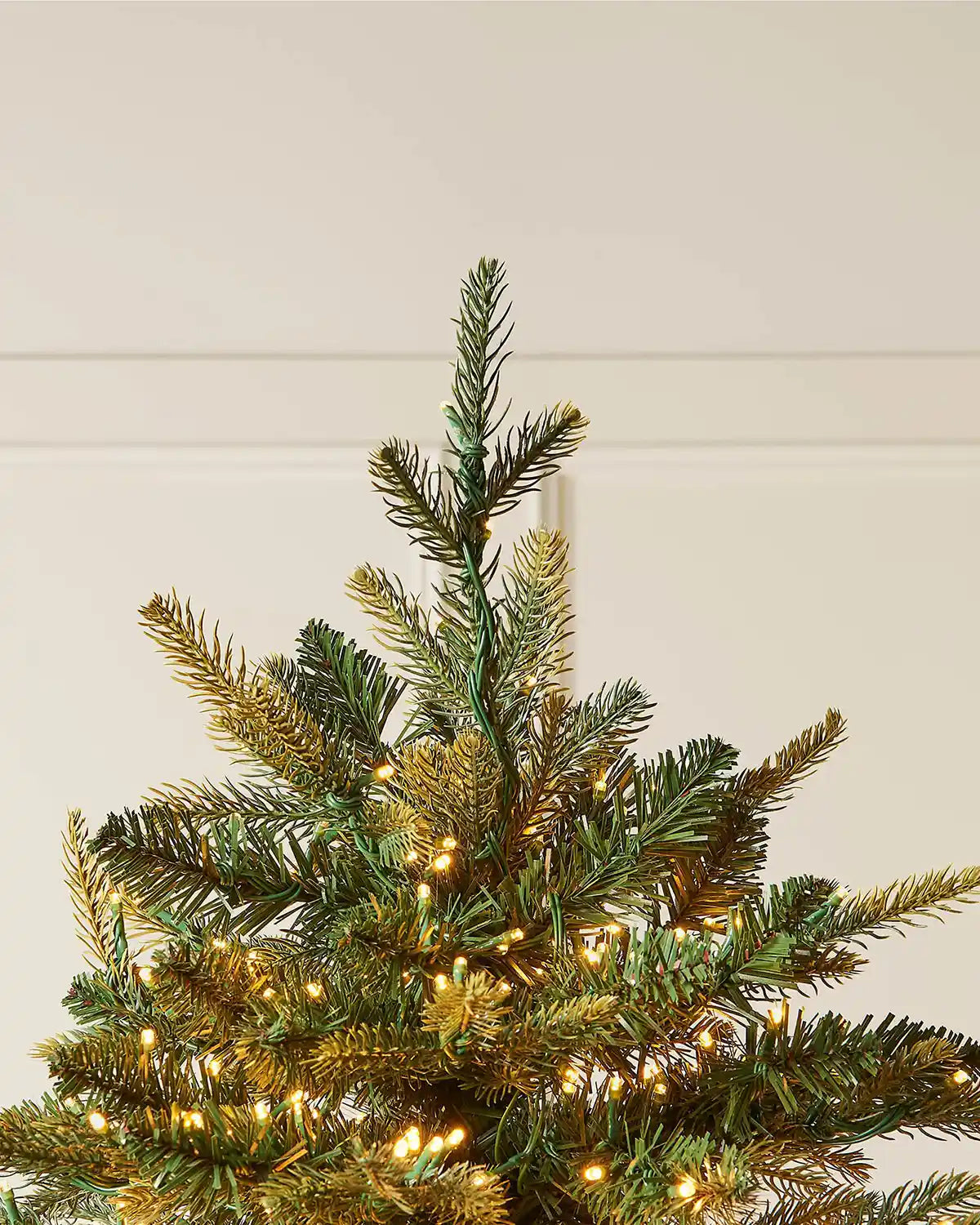 Top section of the 6ft pre-lit Highland fir Christmas tree with shaped branches and warm white lights.