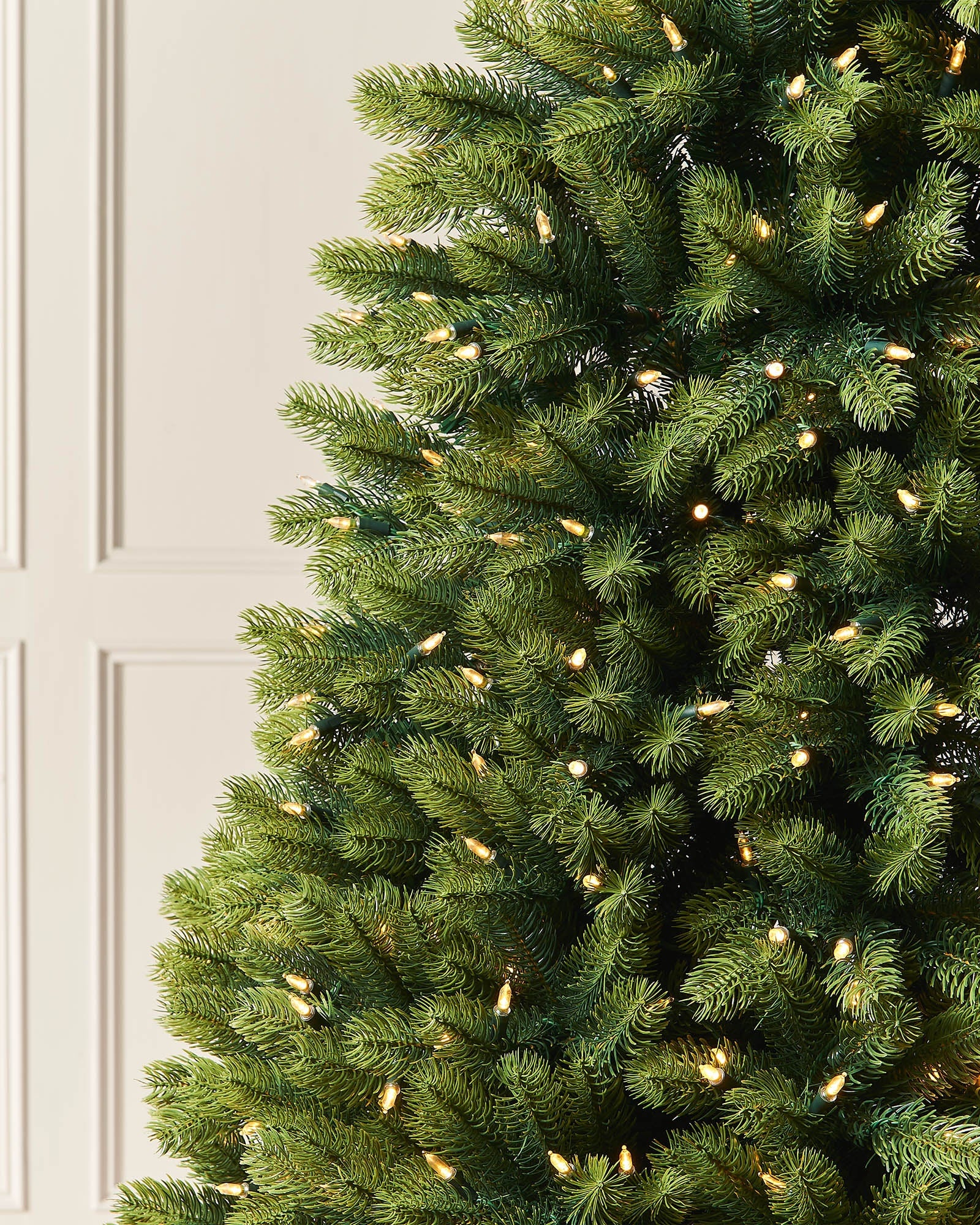 Close-up of mixed pine branches with warm white LEDs on the 6ft pre-lit half Christmas tree.