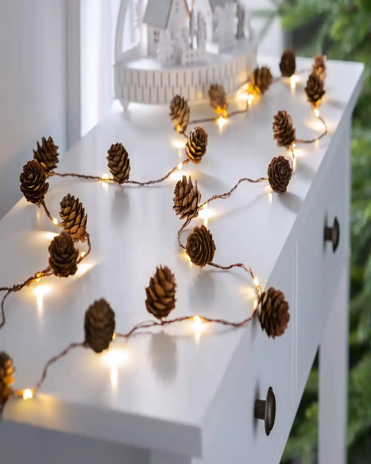 6 ft pre-lit pinecone light string styled on a mantelpiece