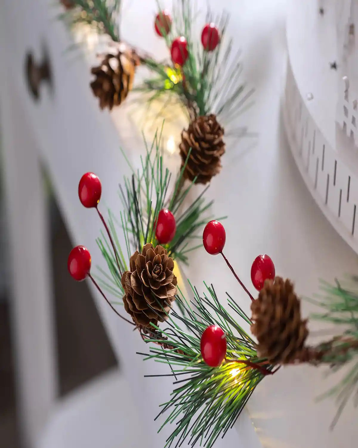 6 ft pre-lit pinecones and berries light string styled on a mantelpiece