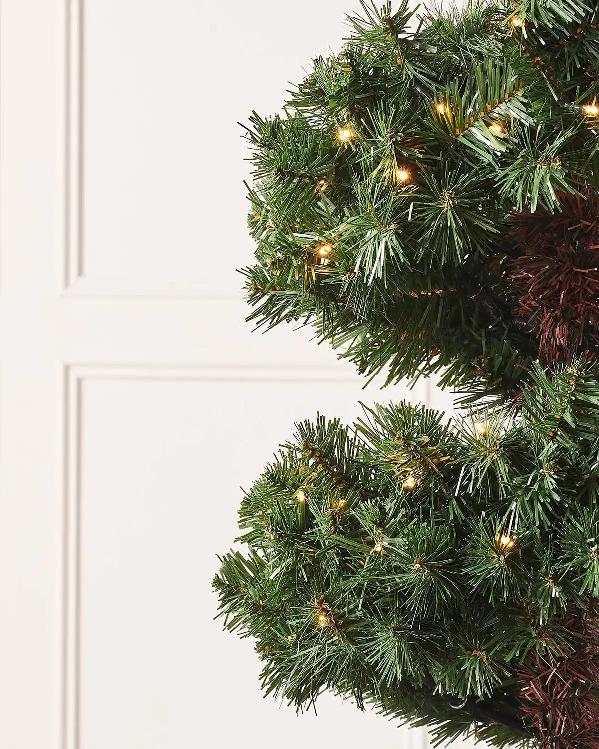 Detail of the spiral potted Christmas tree foliage with warm white lights
